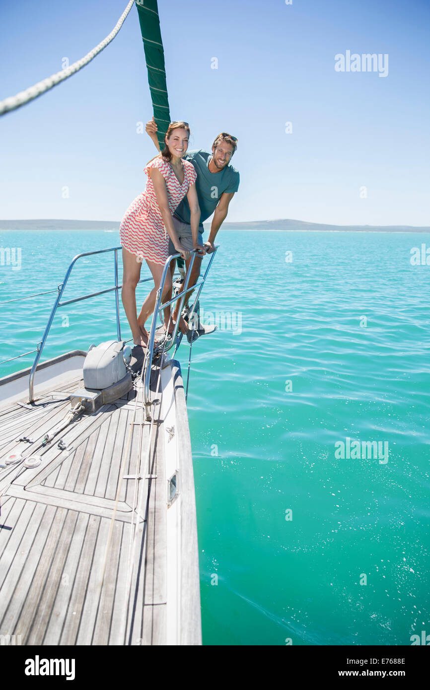 Couple standing on front of sailboat Stock Photo