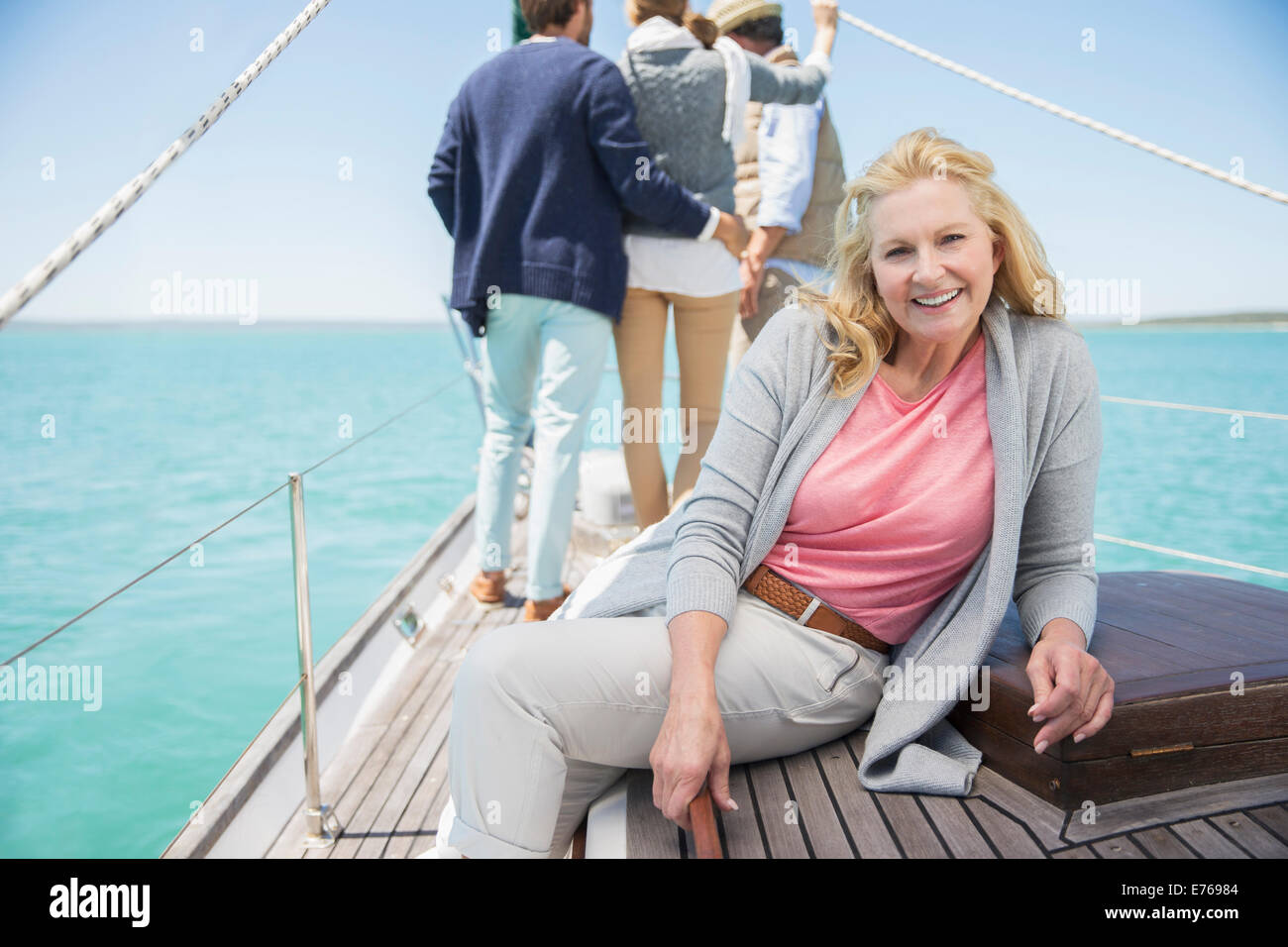 Older woman sitting on boat relaxing with family Stock Photo