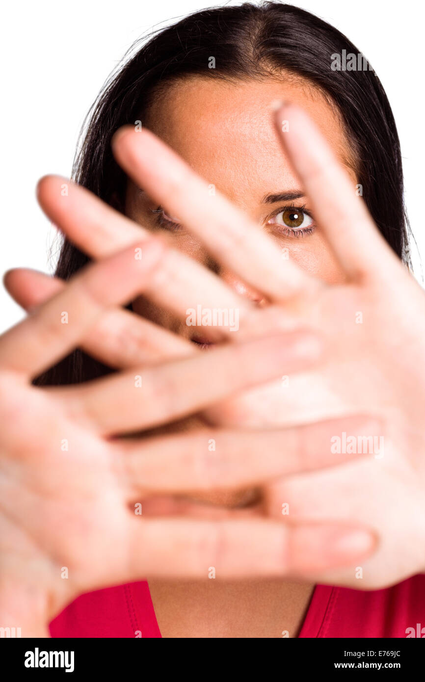 Young brunette hiding behind hands Stock Photo