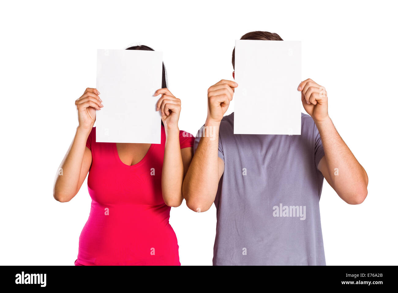 Couple covering faces with paper Stock Photo
