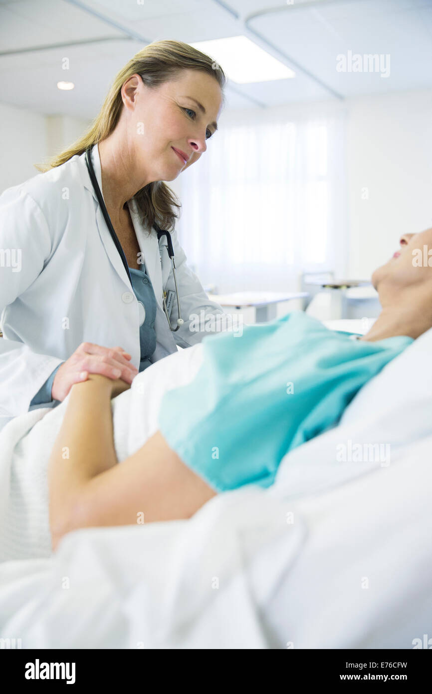 Doctor talking to patient in hospital room Stock Photo