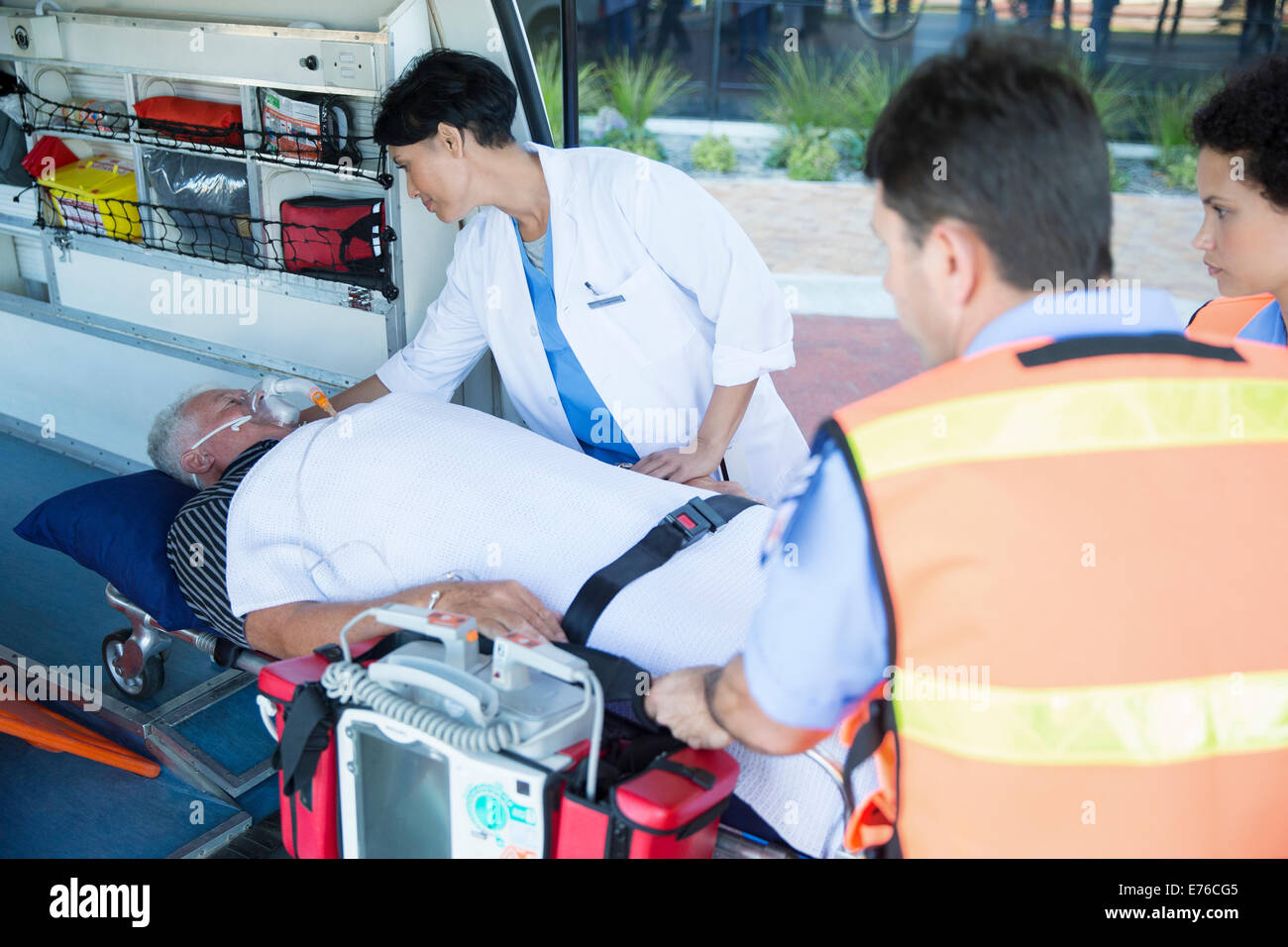 Doctor examining patient on ambulance stretcher Stock Photo