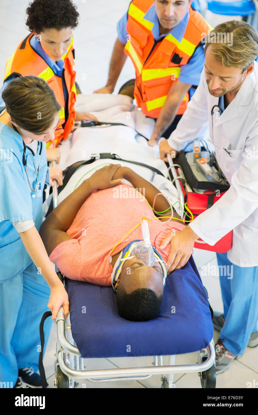 Doctor, nurse and paramedics examining man on stretcher Stock Photo