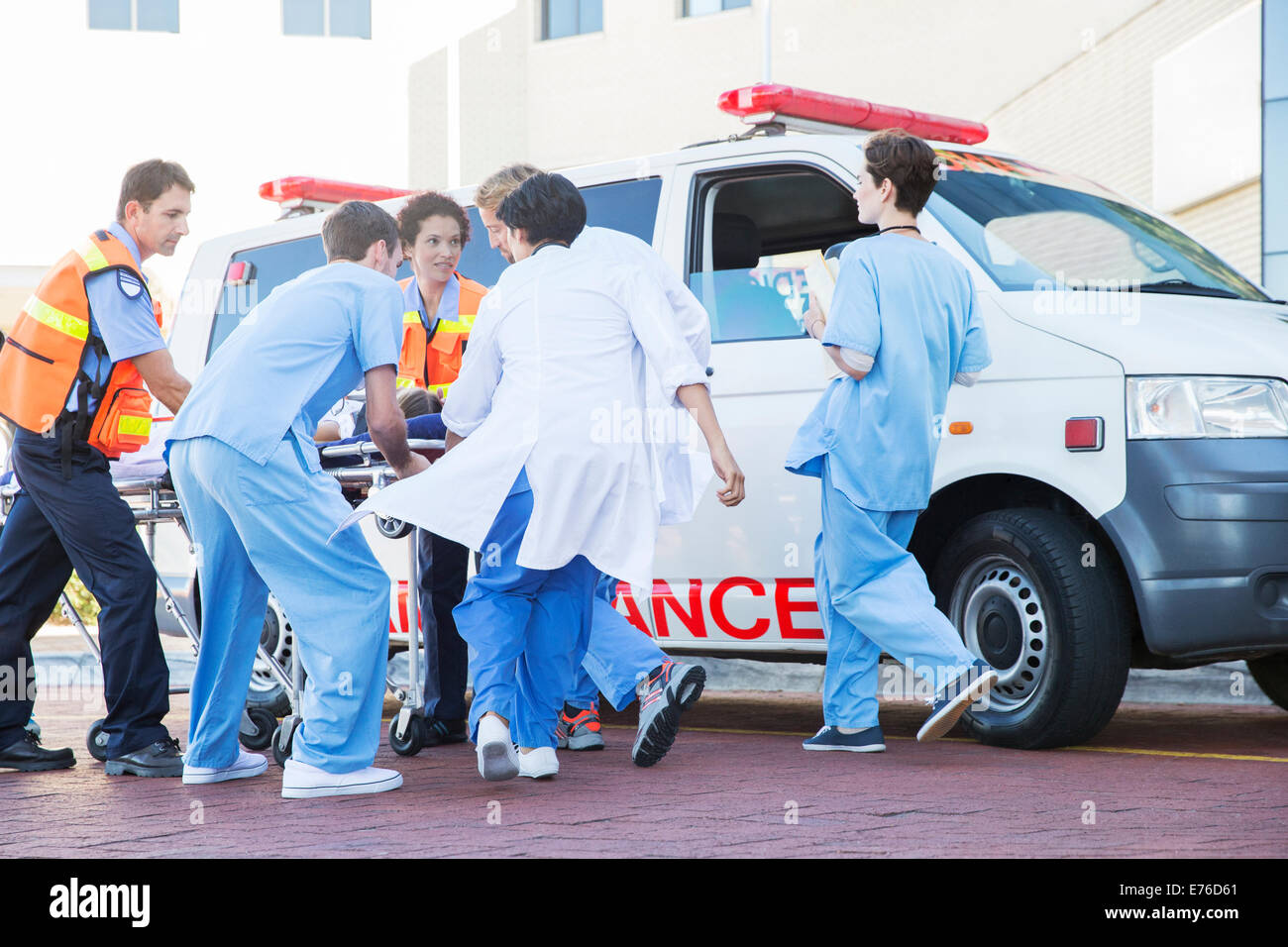 Doctors, nurses, and paramedic examining patient on stretcher Stock Photo