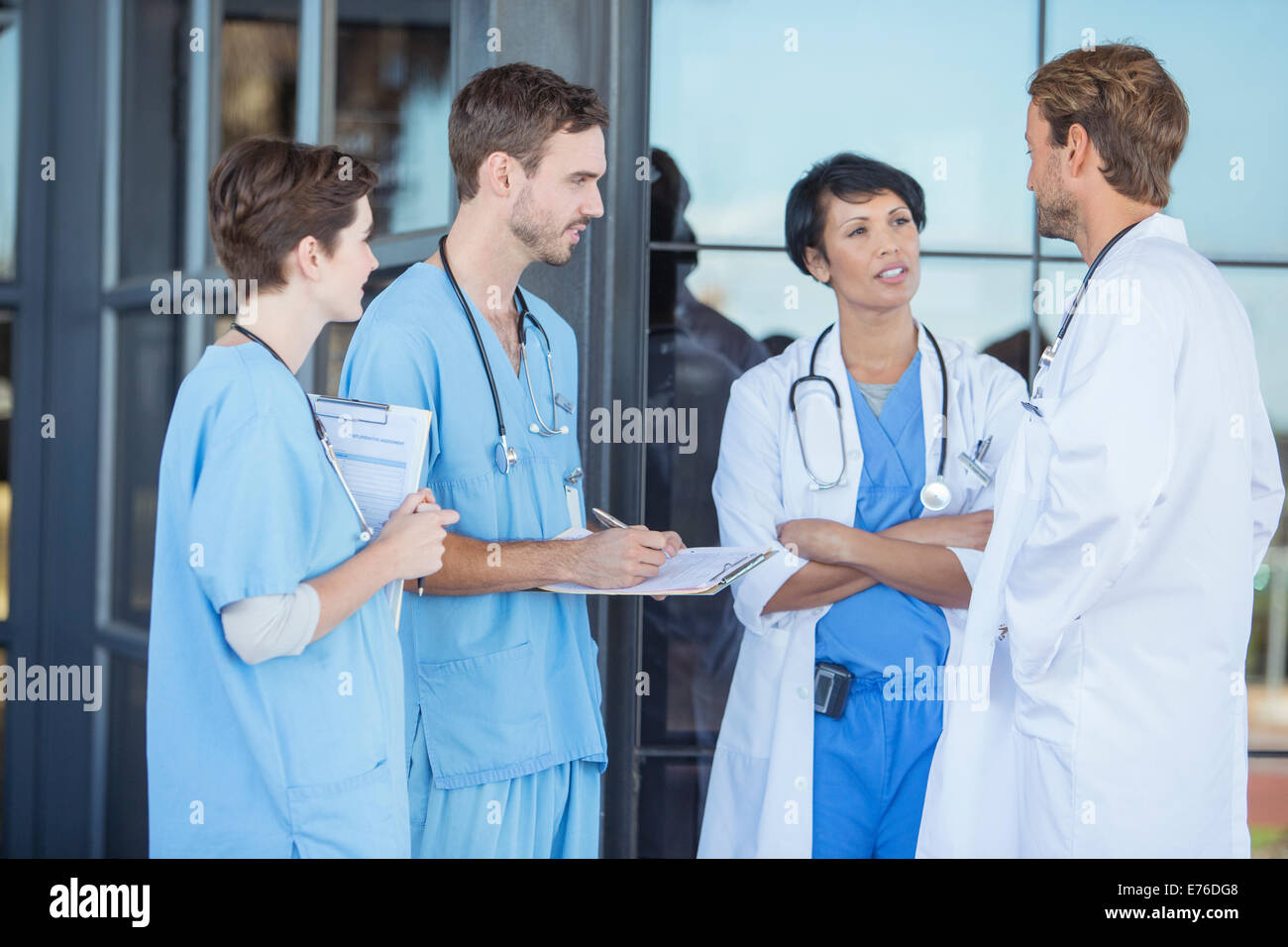 Doctors and nurses talking outside hospital Stock Photo