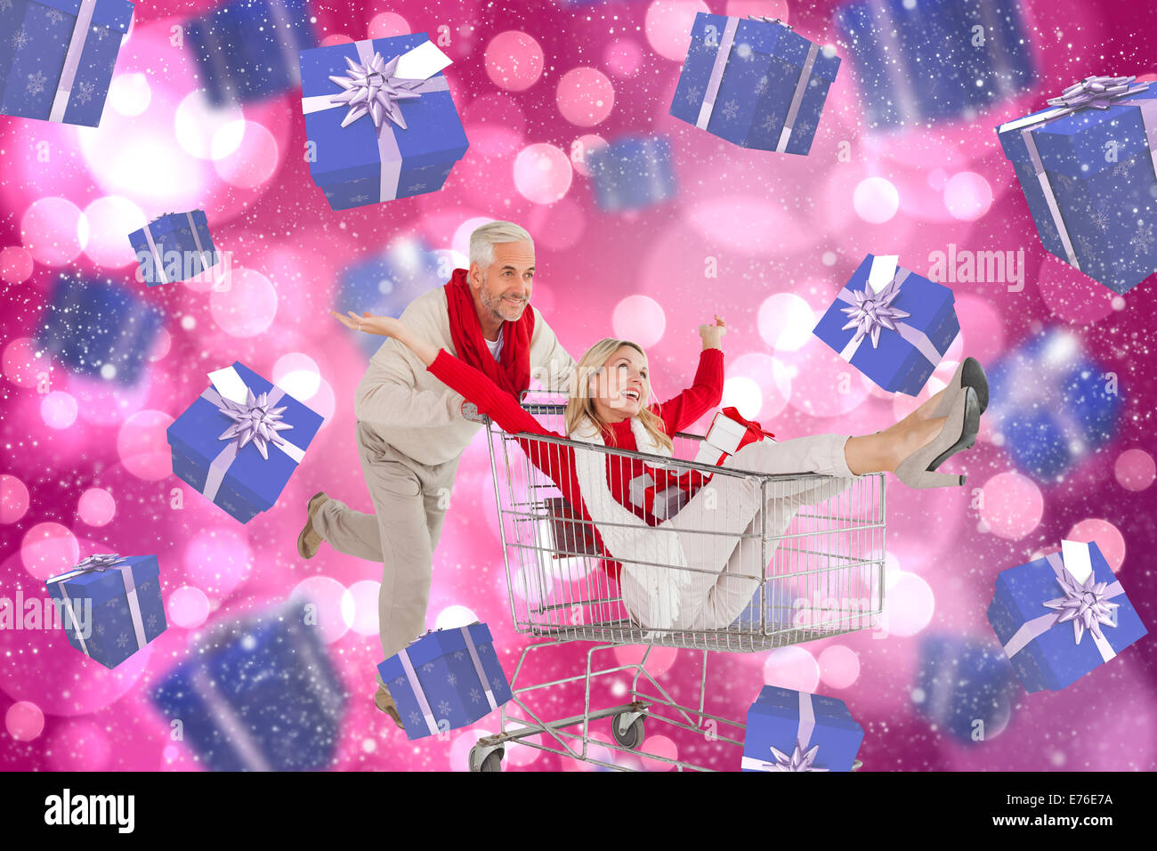 Composite image of happy festive couple messing in trolley Stock Photo