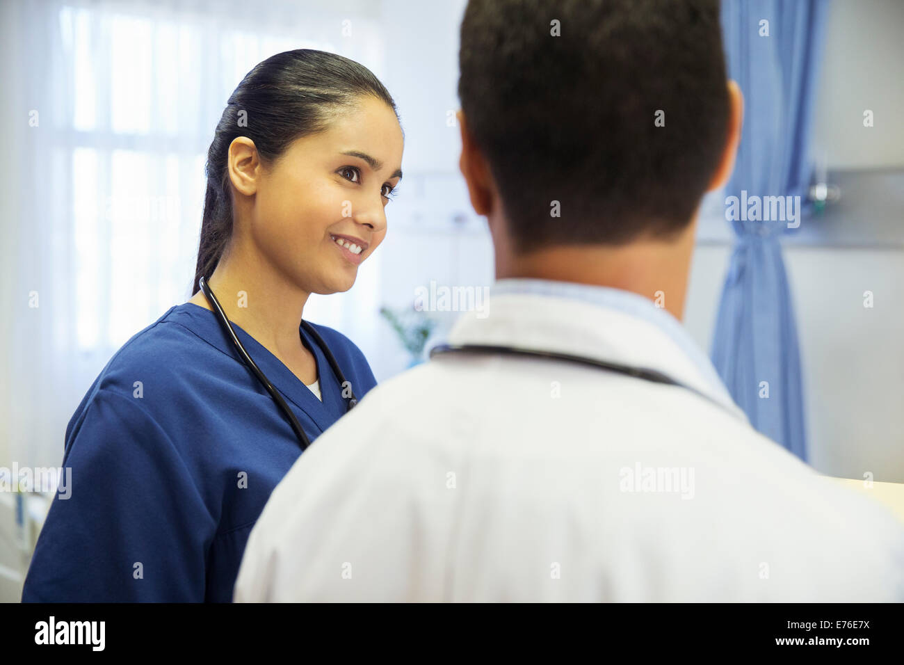 Doctor and nurse talking in hospital room Stock Photo