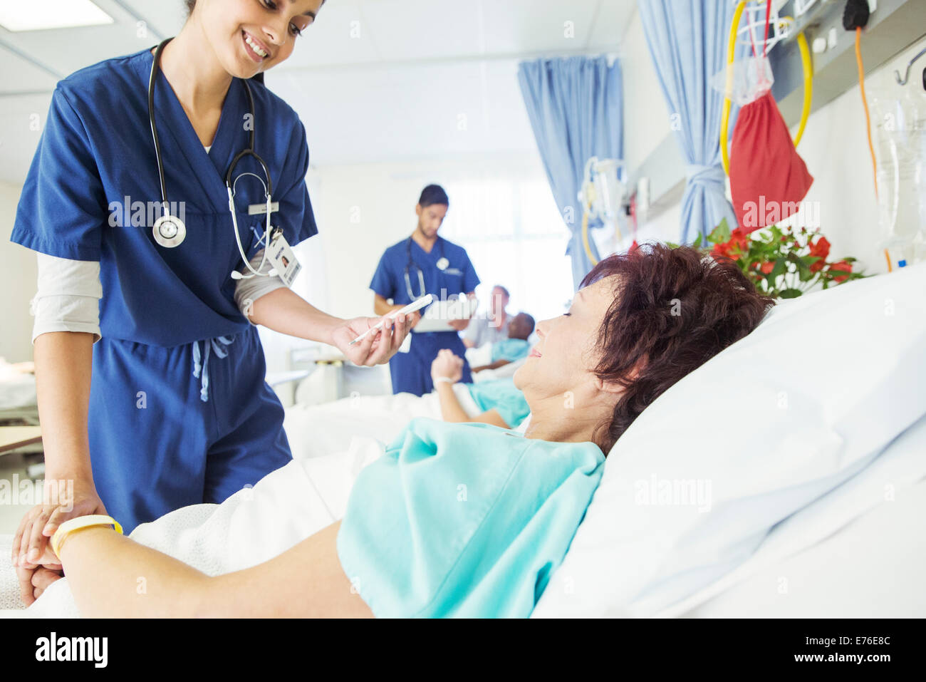 Nurse examining patient in hospital room Stock Photo