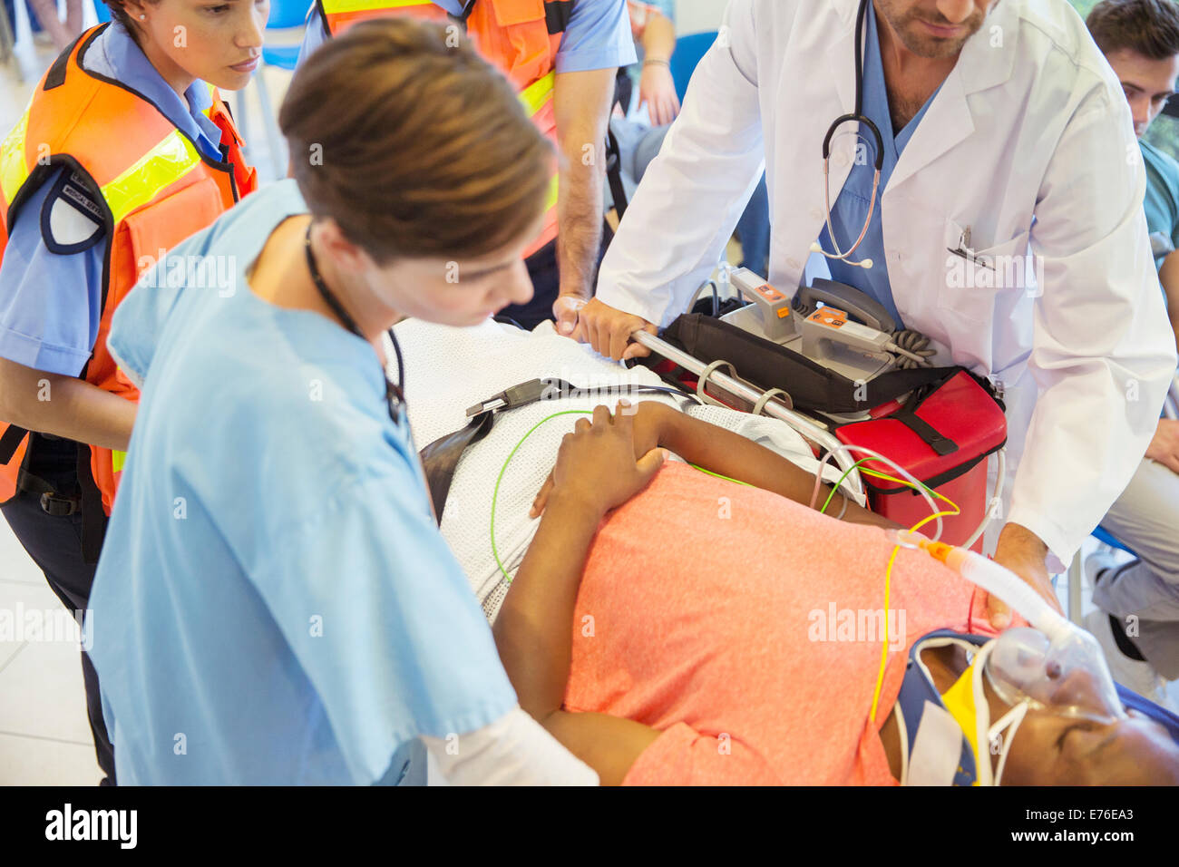 Doctor, nurse and paramedics examining patient on stretcher Stock Photo