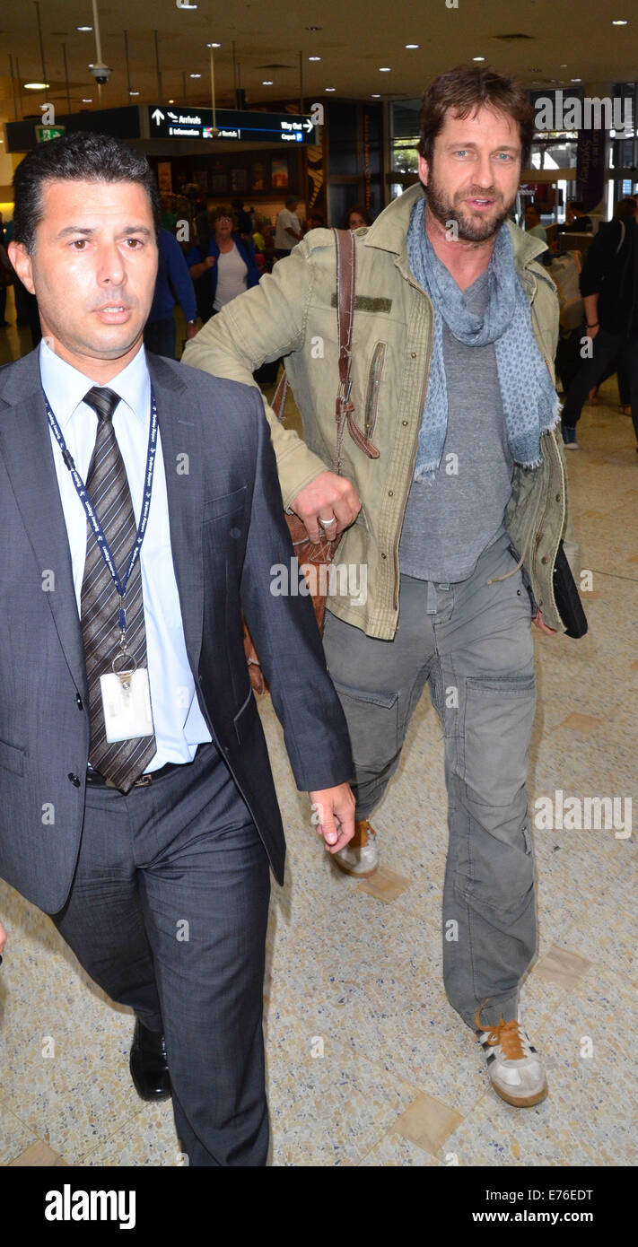 Gerard Butler wearing a light olive green jacket and cargo trousers