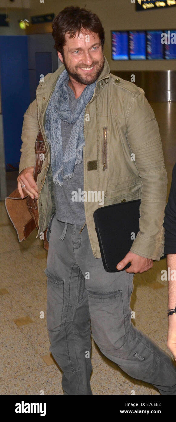 Gerard Butler wearing a light olive green jacket and cargo trousers