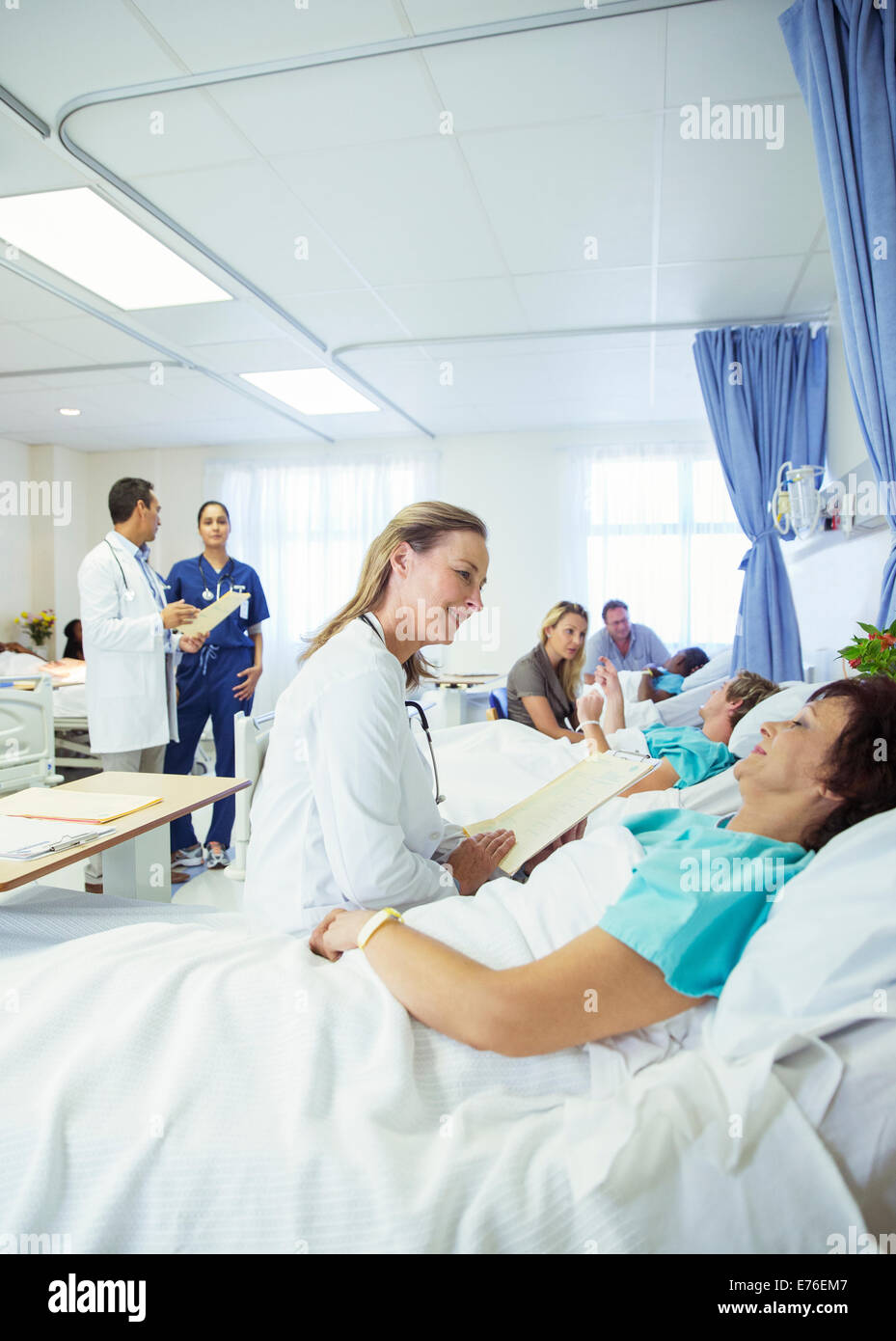 Doctor talking to patient in hospital room Stock Photo
