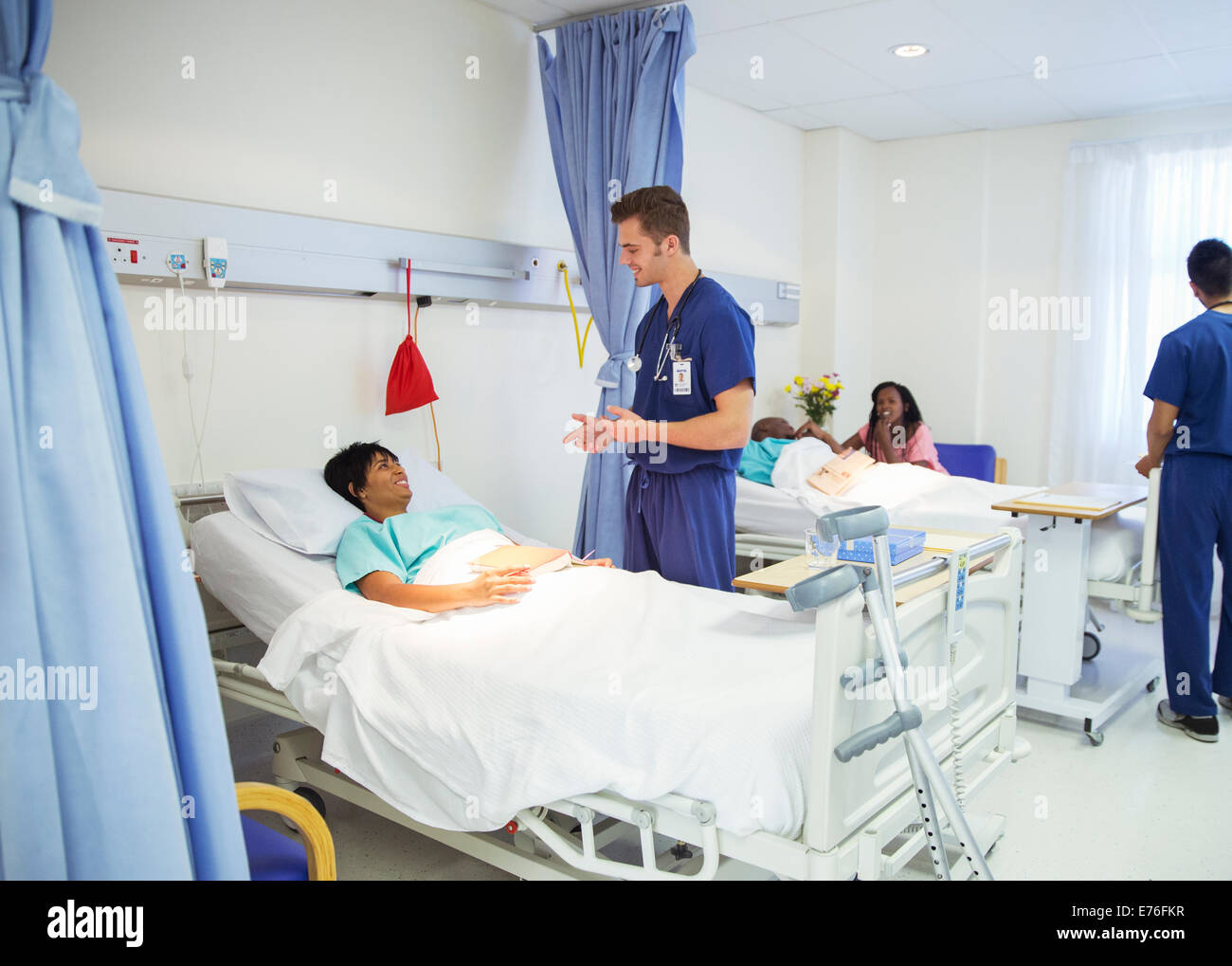 Nurse talking to patient in hospital room Stock Photo