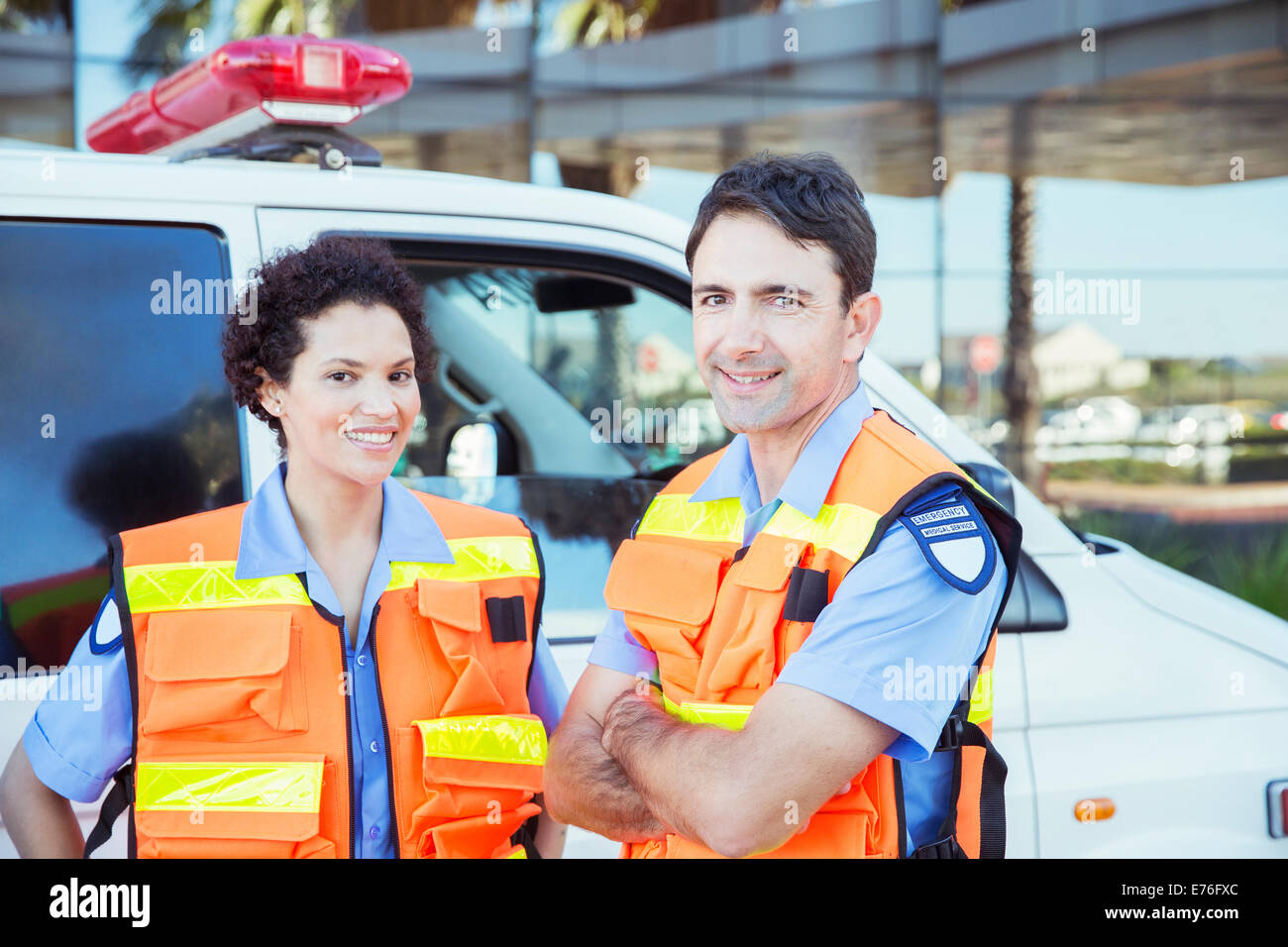 Paramedics smiling outside ambulance Stock Photo