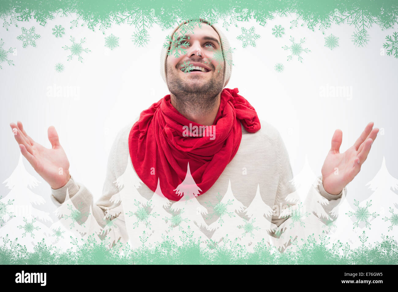 Composite image of attractive young man in warm clothes with hands up Stock Photo
