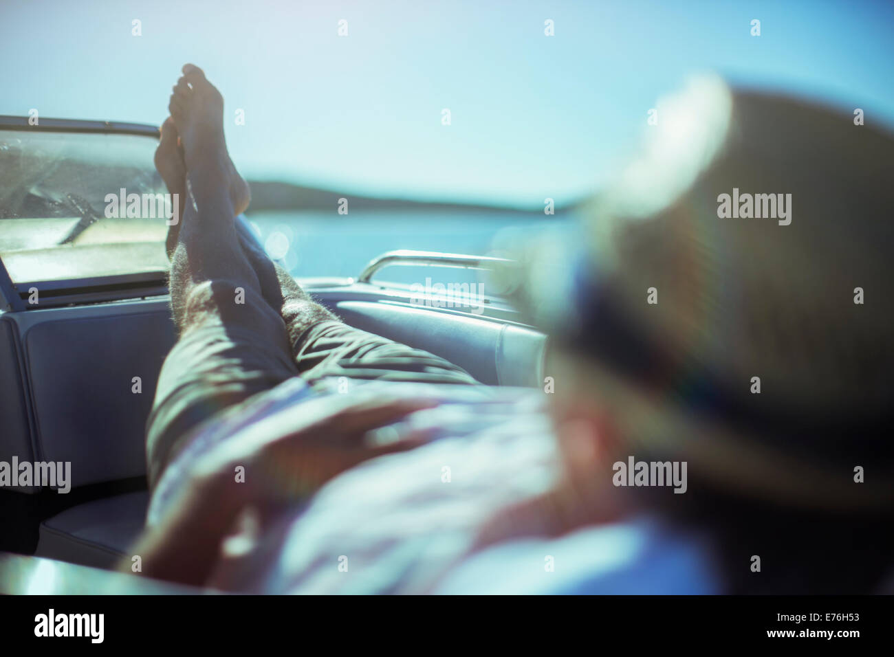 Man relaxing on boat near beach Stock Photo