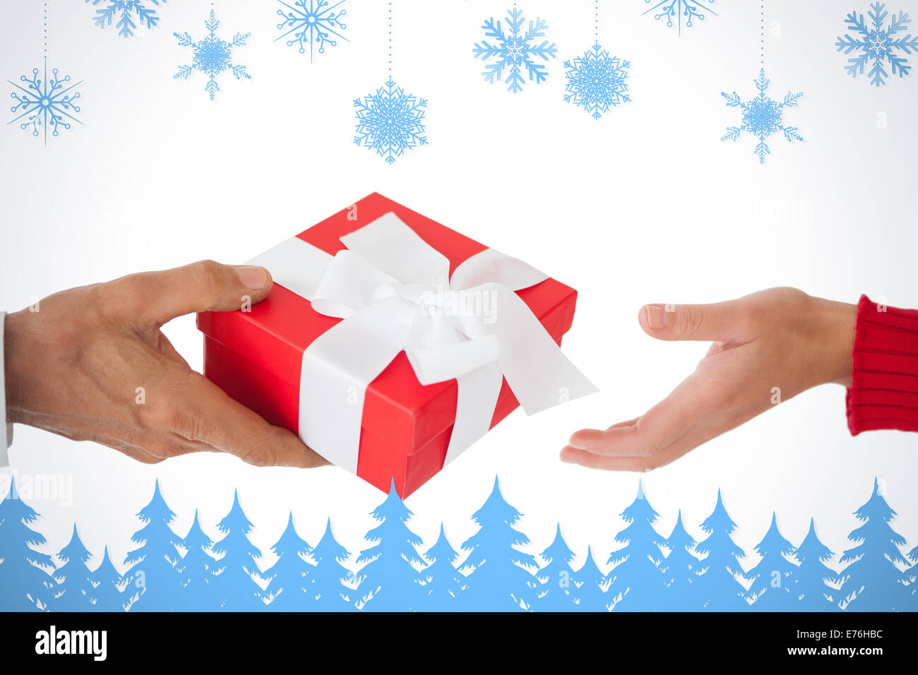 Composite image of couple passing a wrapped gift Stock Photo