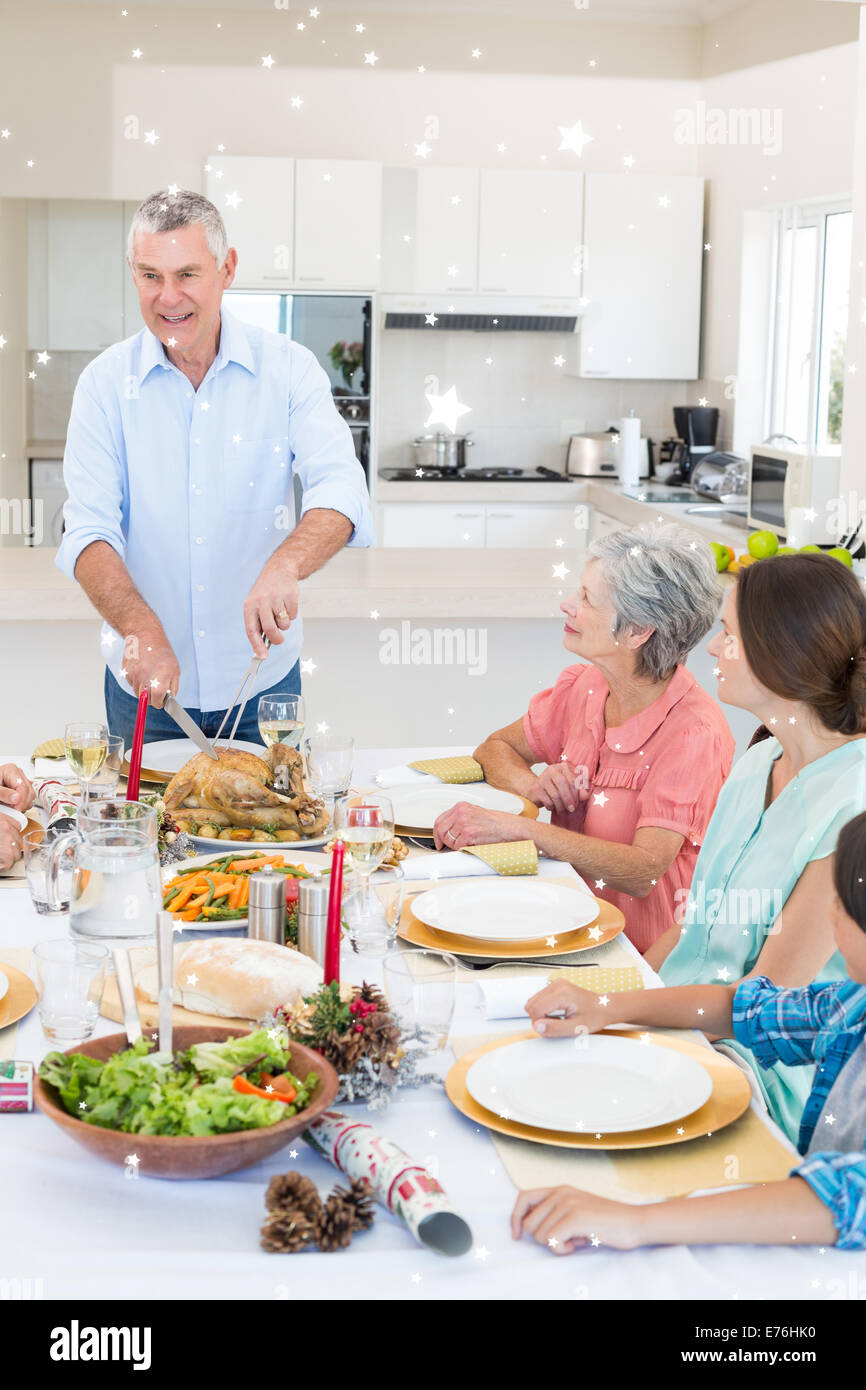 Composite image of senior man serving meal to family Stock Photo