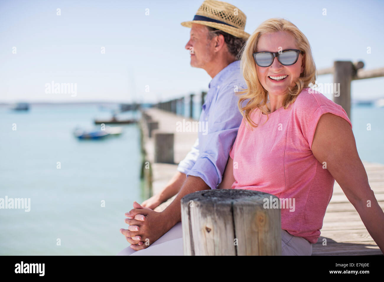 Couple holding hands together on wooden dock Stock Photo