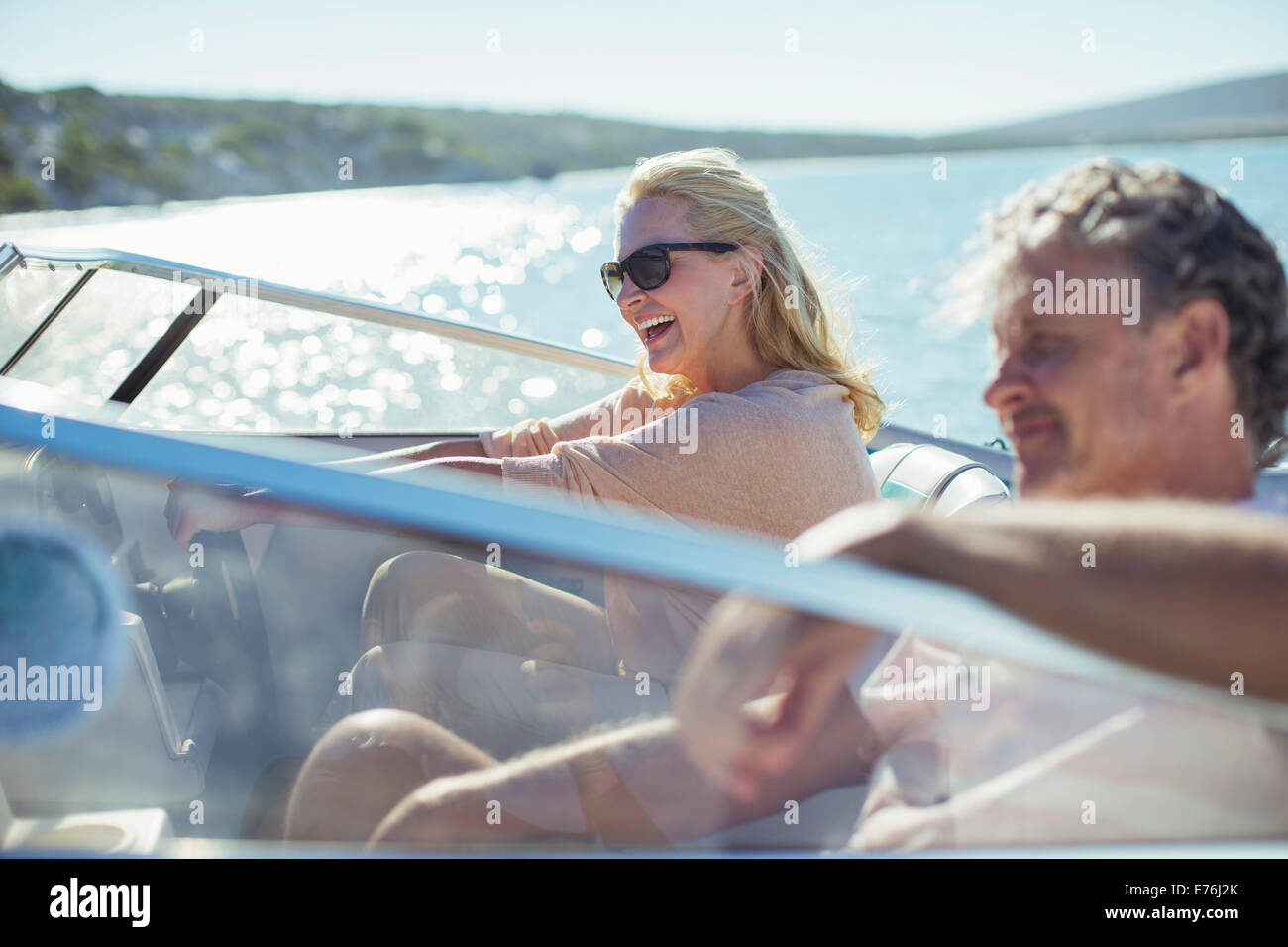 Couple driving boat in water Stock Photo