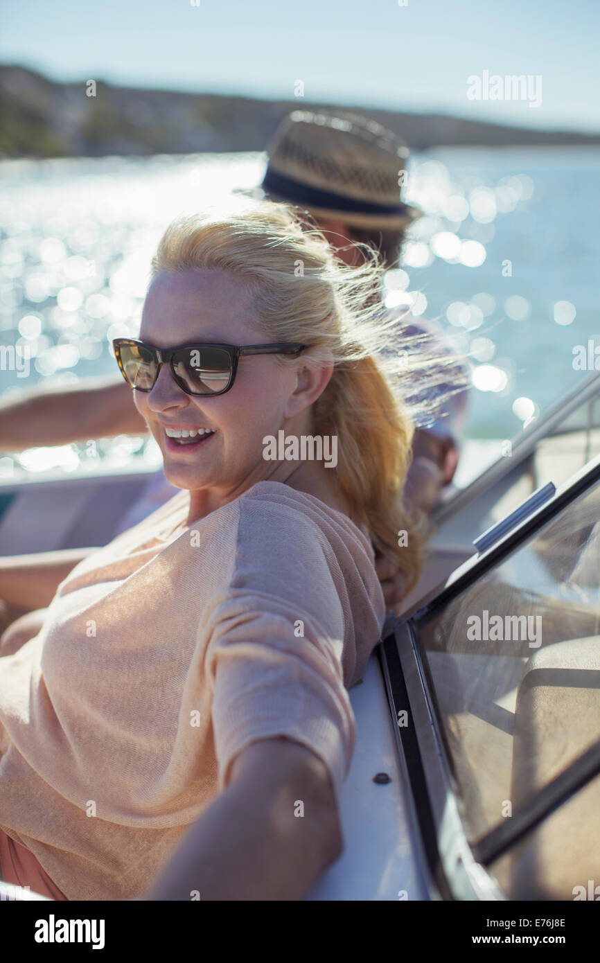 Older woman relaxing in boat with family Stock Photo