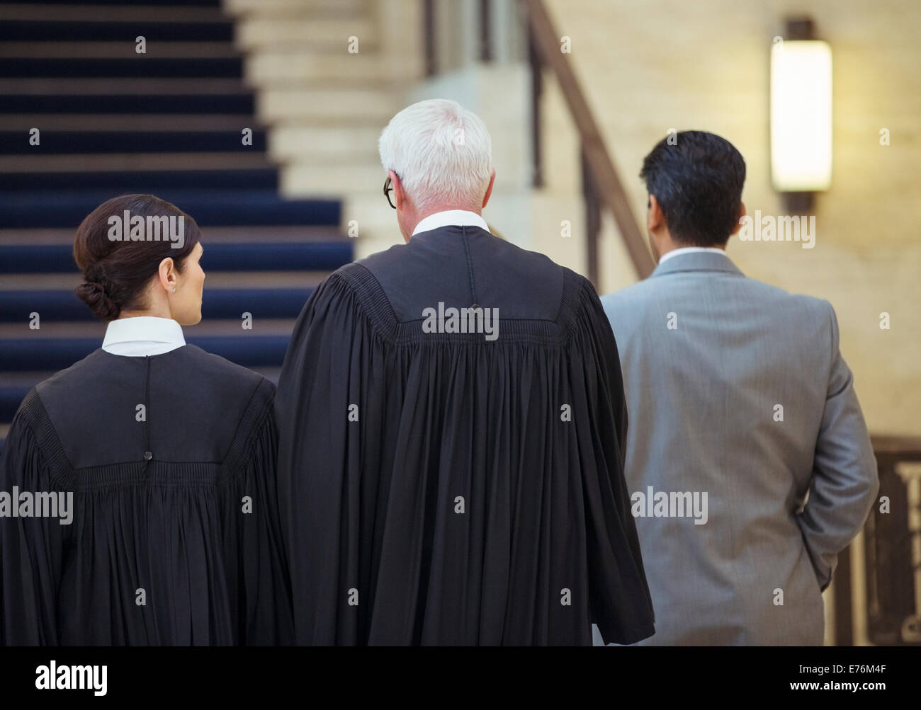 Judges and lawyer walking through courthouse together Stock Photo