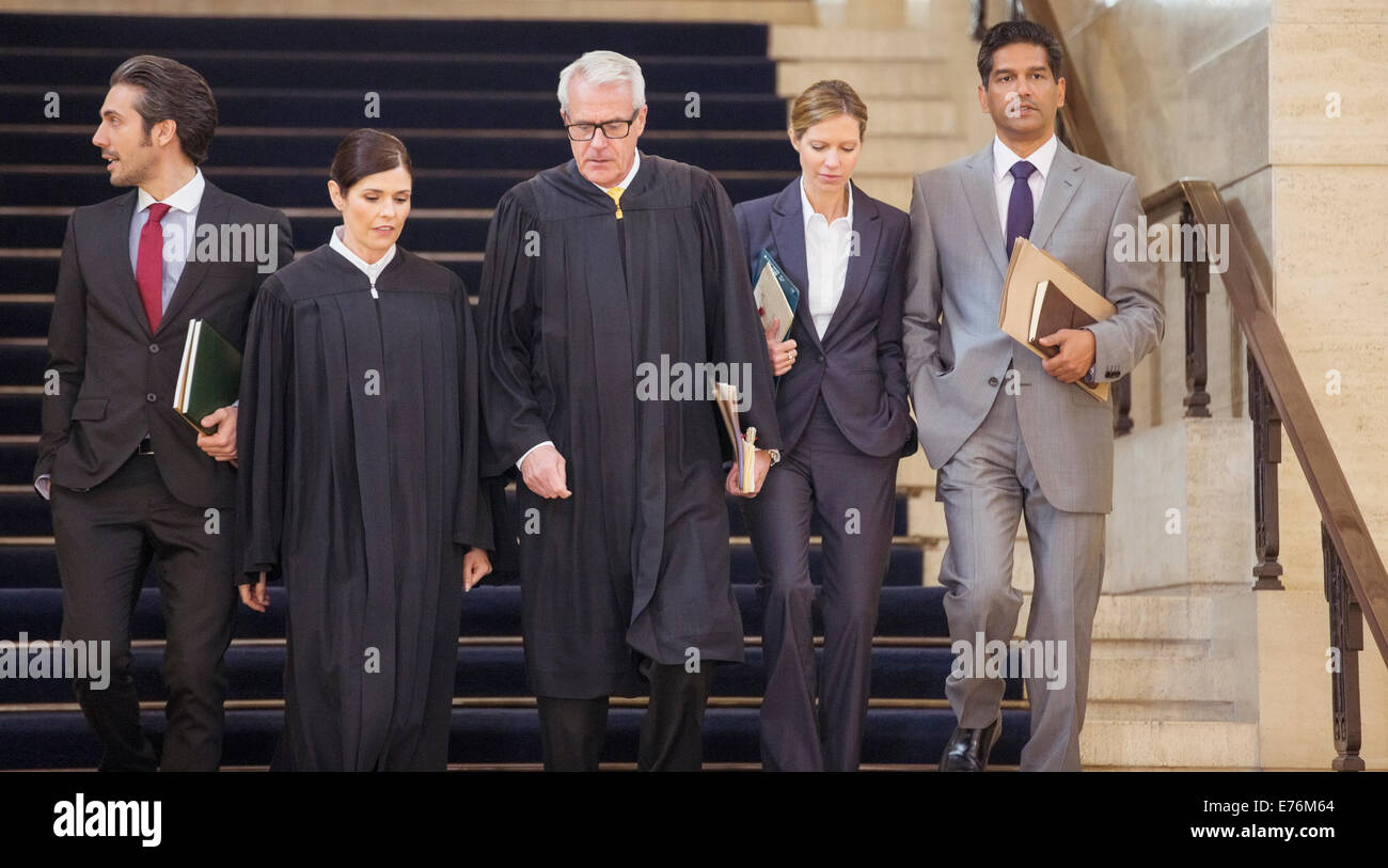 Judges and lawyers walking through courthouse together Stock Photo