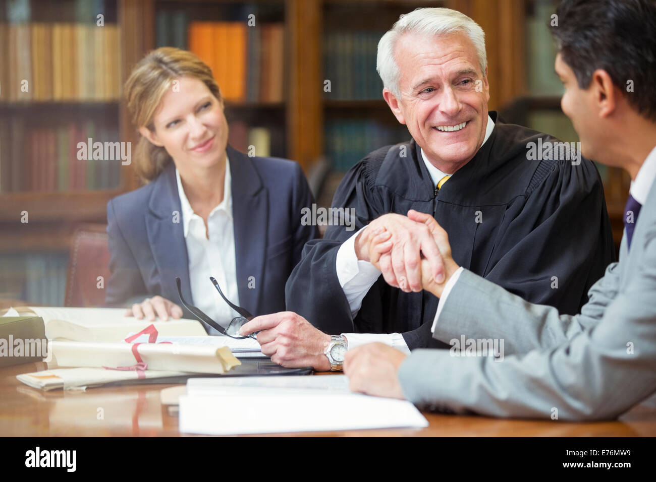 Judge and lawyer shaking hands in chambers Stock Photo