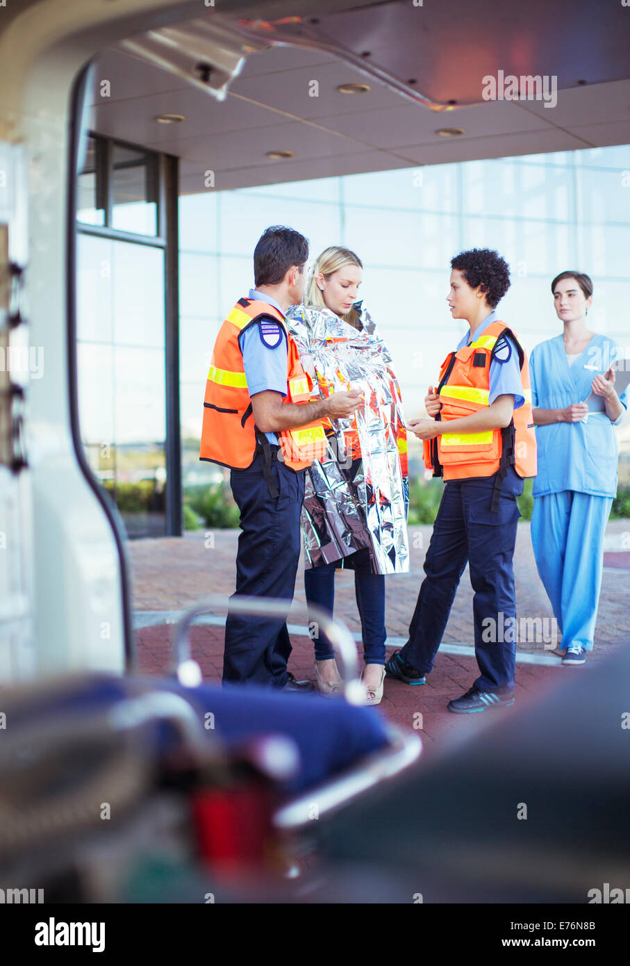Paramedics talking to patient in hospital parking lot Stock Photo Alamy