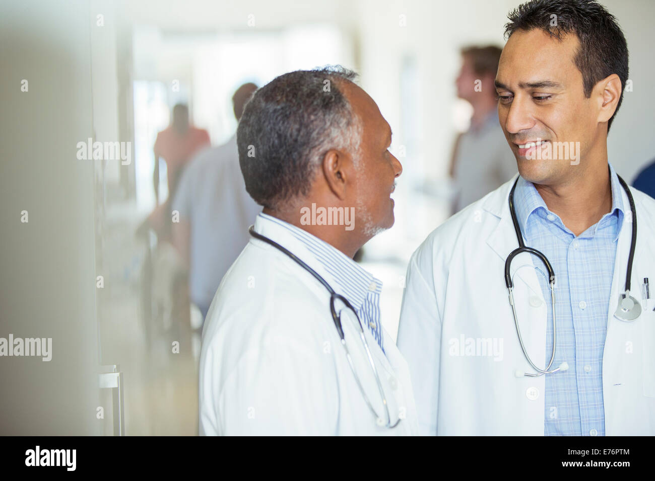 Doctors talking in hospital hallway Stock Photo