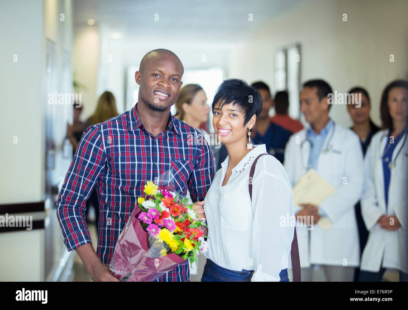 Couple carrying bouquet of flowers in hospital Stock Photo
