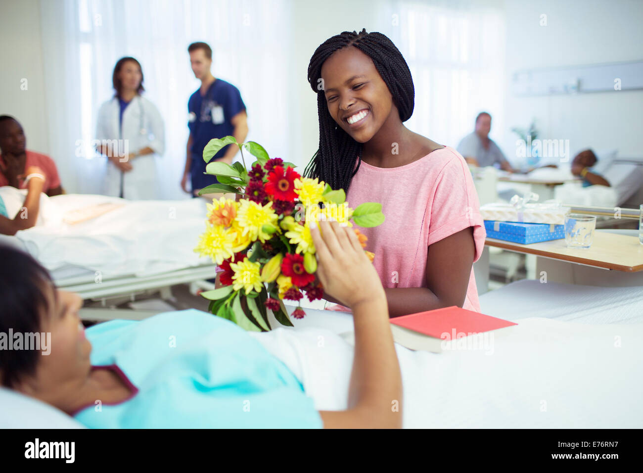 Woman giving mother bouquet of flowers in hospital Stock Photo