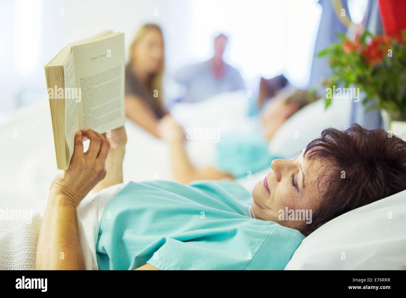 Patient reading in hospital room Stock Photo