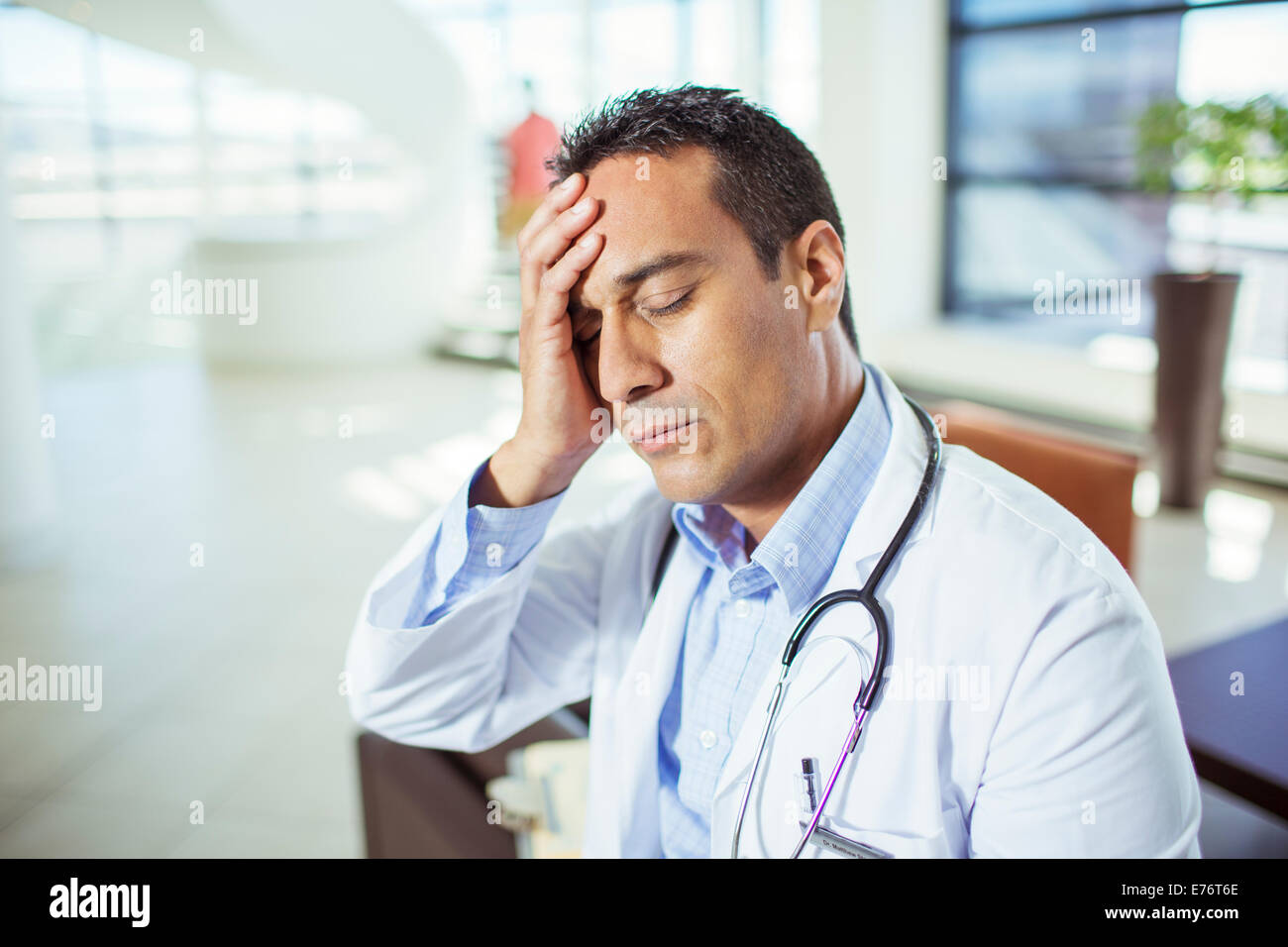 Doctor holding his forehead in hospital Stock Photo