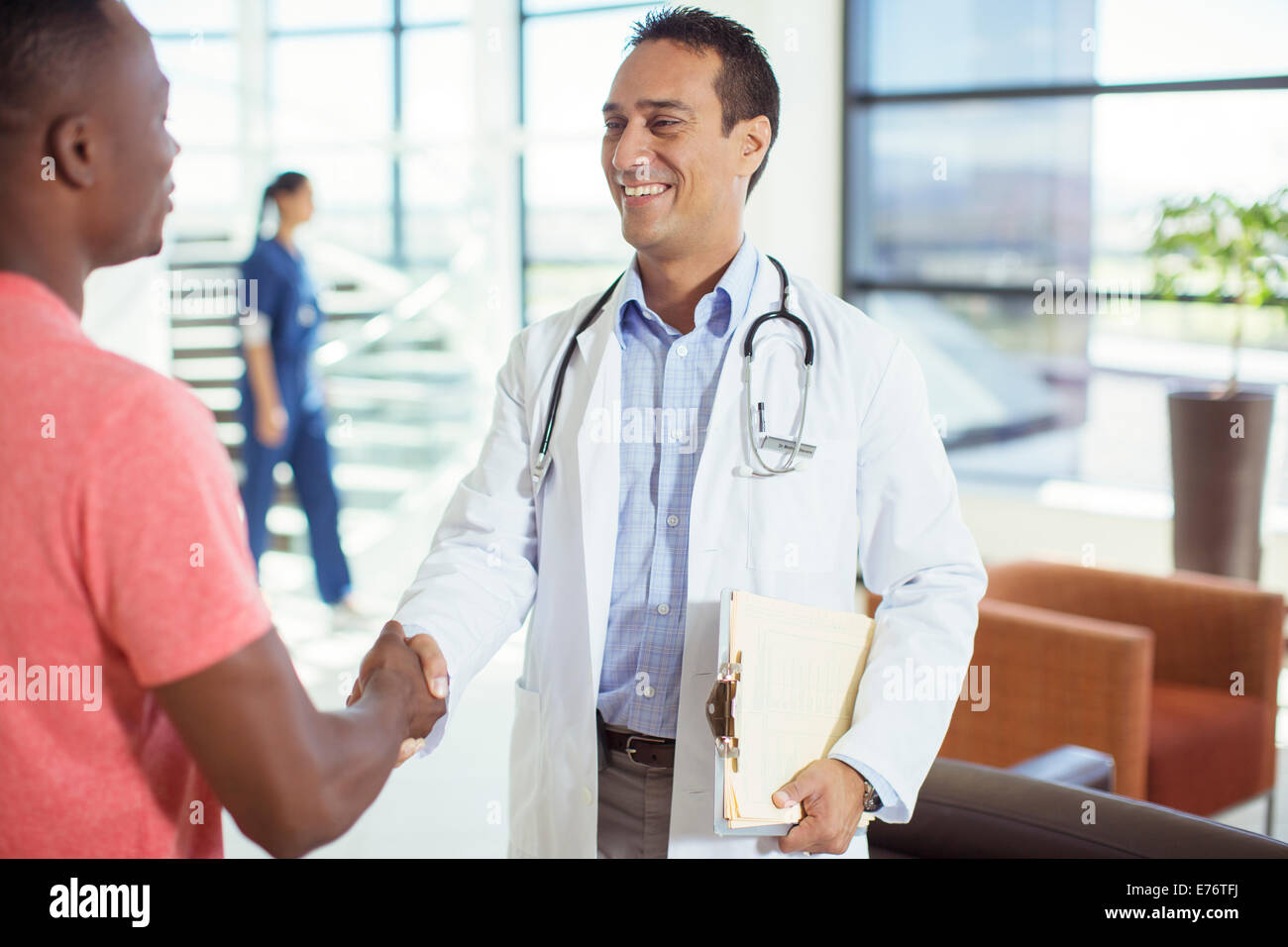 Doctor and patient shaking hands in hospital Stock Photo