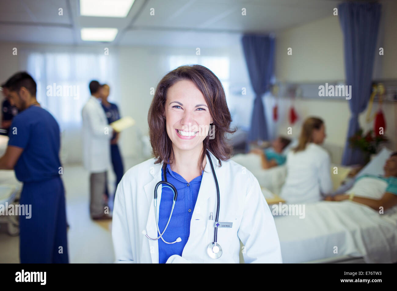 Doctor smiling in hospital room Stock Photo