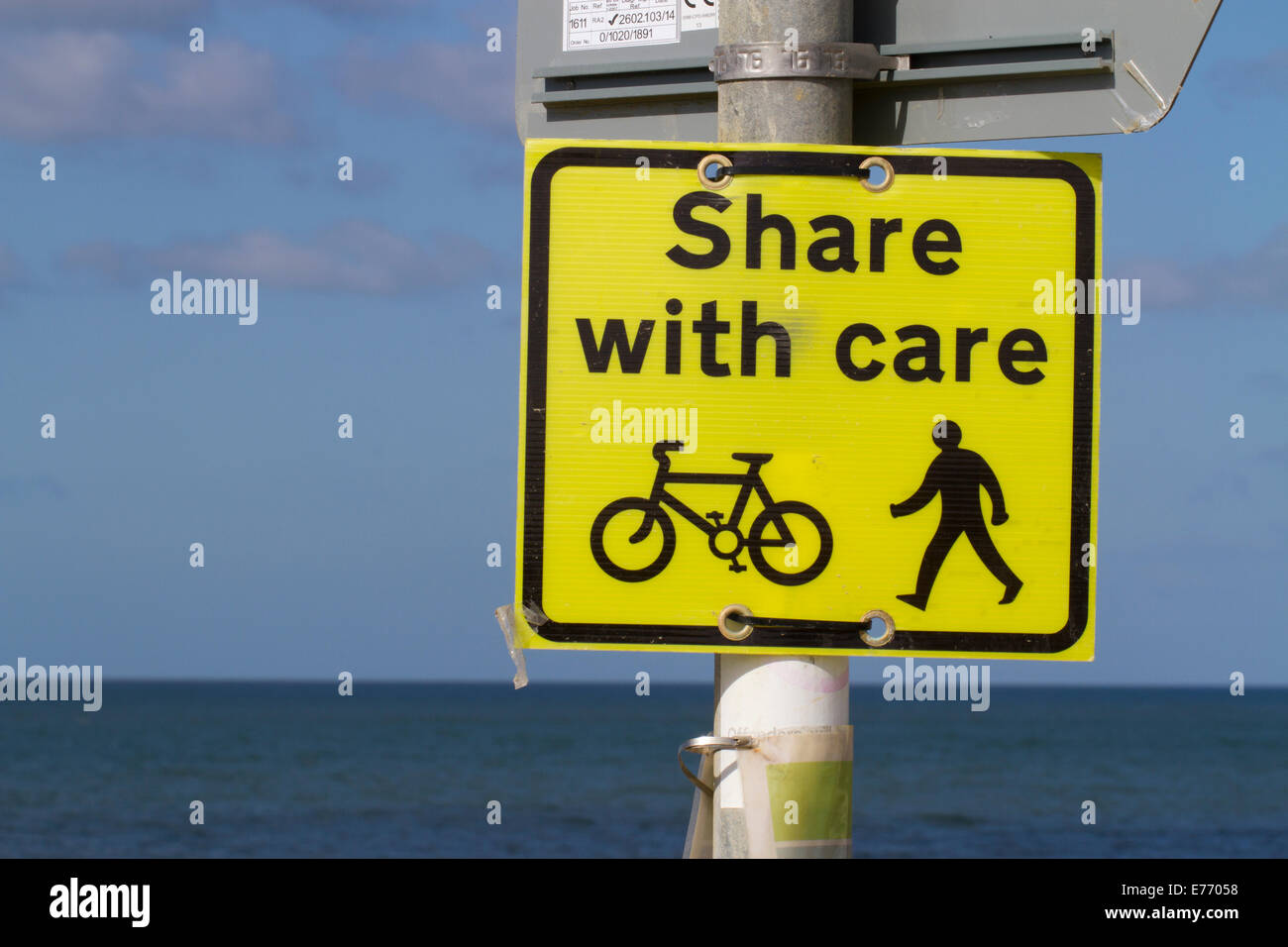 'Share with care' sign on seaside promenade shared by cyclists and walkers. Seaford, Sussex. April. Stock Photo