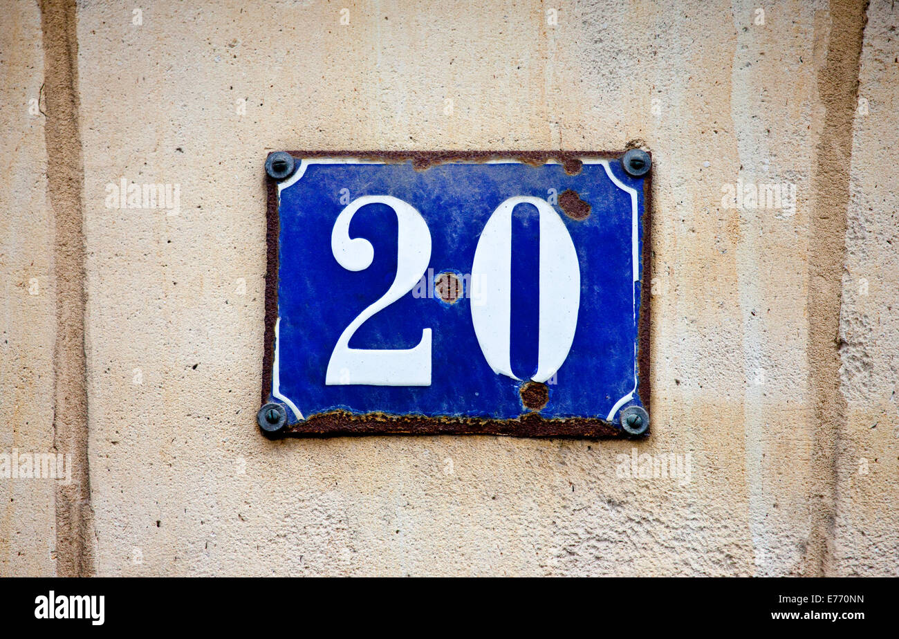 A plaque depicting the number 20 on a rough textured wall. Stock Photo