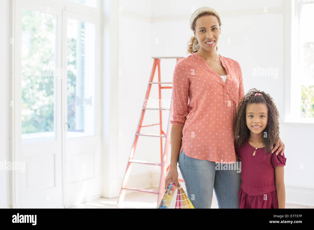 Mother and daughter smiling in living space Stock Photo