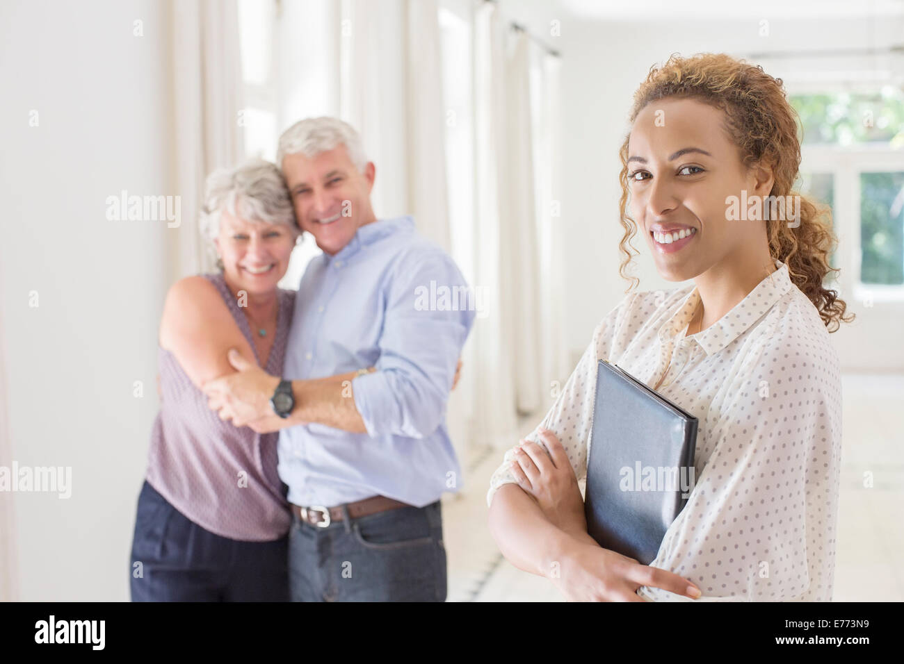 Older couple hugging with woman smiling Stock Photo