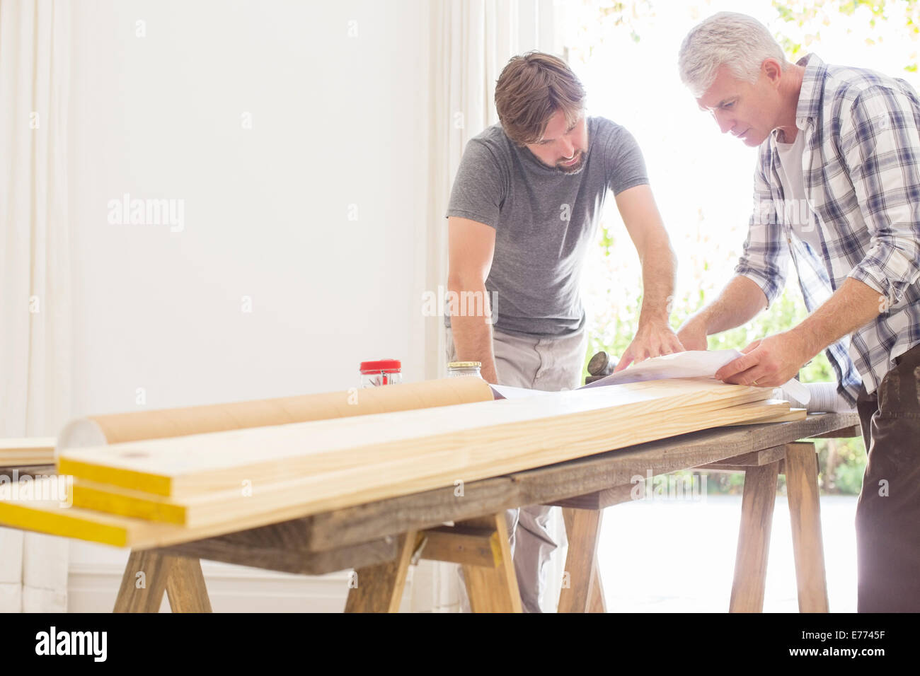 Father and son looking through construction plans Stock Photo