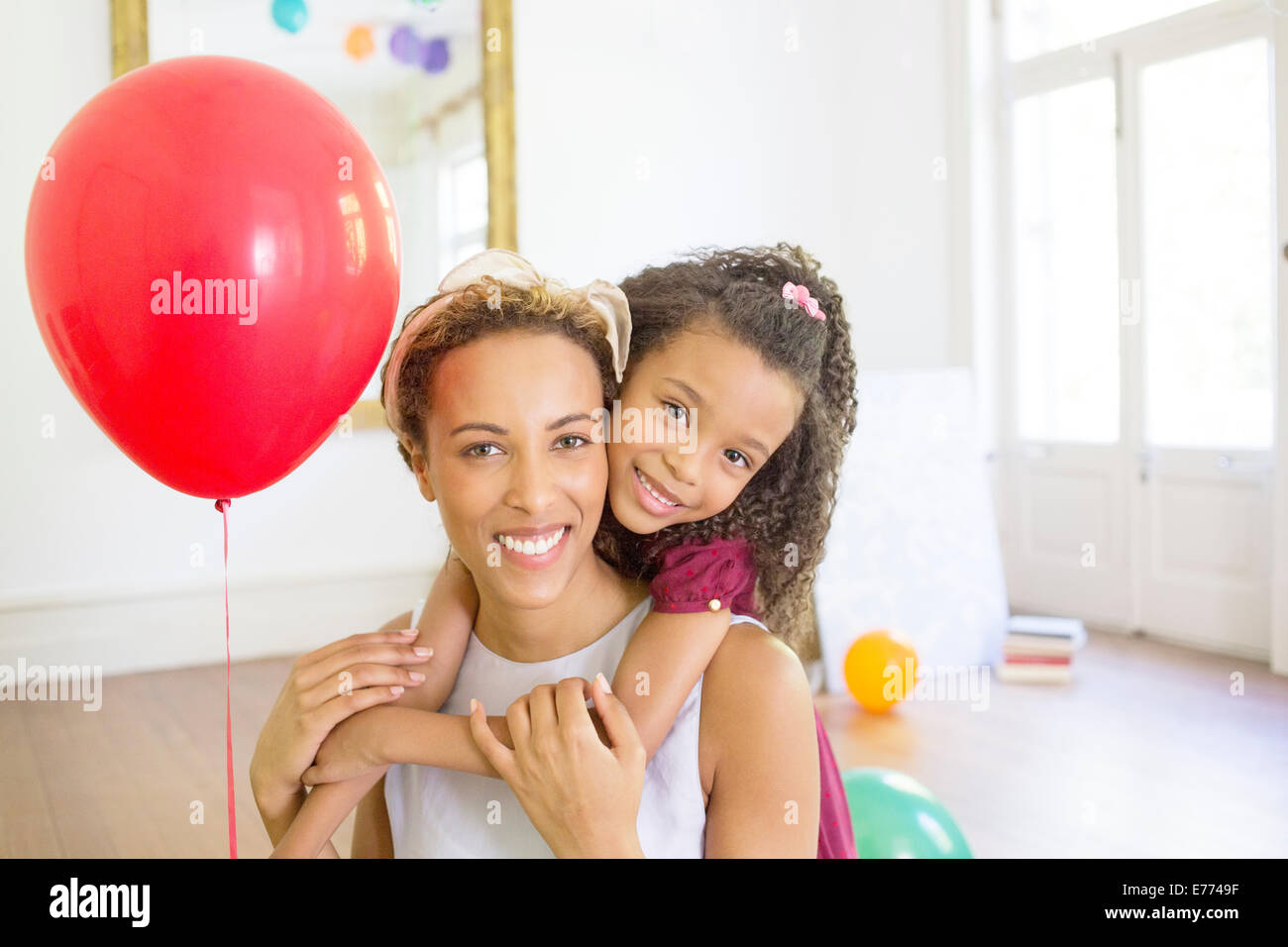 Mother and daughter hugging in living space Stock Photo