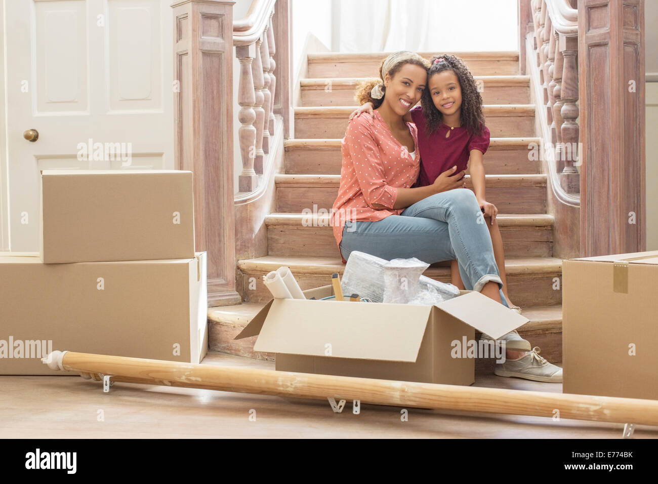 Mother and daughter hugging on stairs Stock Photo