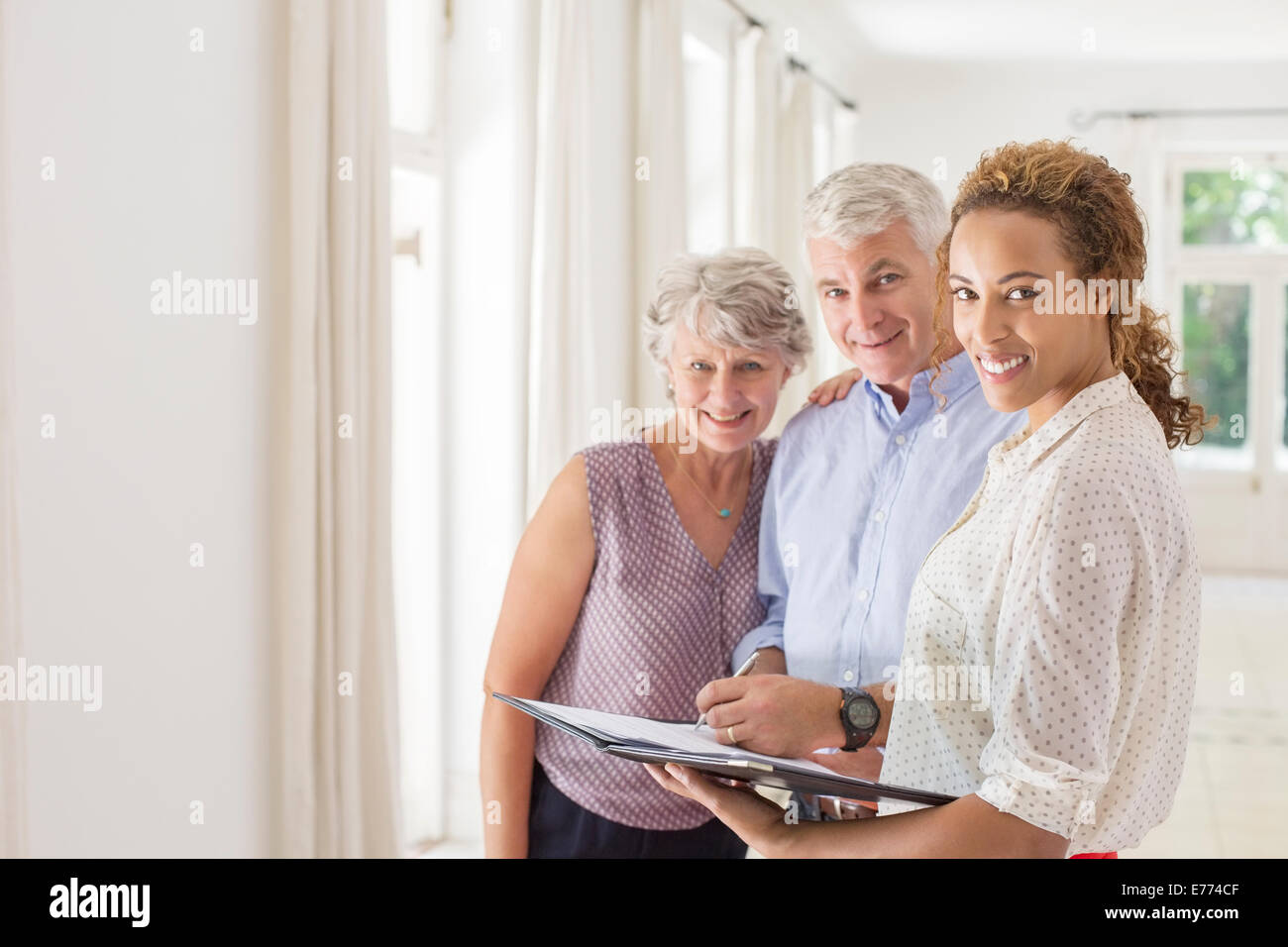 Older couple and woman signing documents Stock Photo