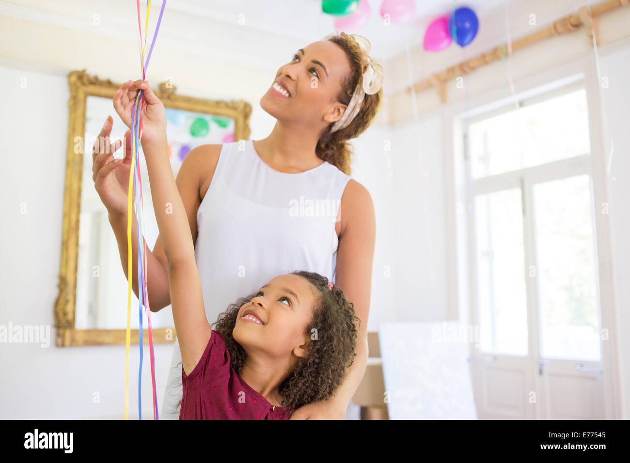 Mother and daughter holding balloons together Stock Photo
