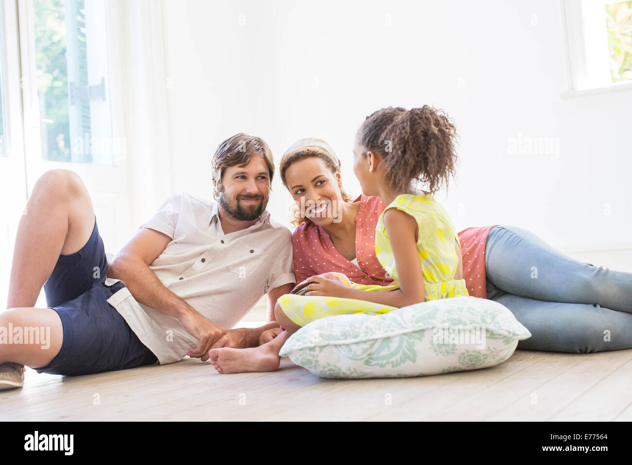 Family sitting on the ground in living space Stock Photo