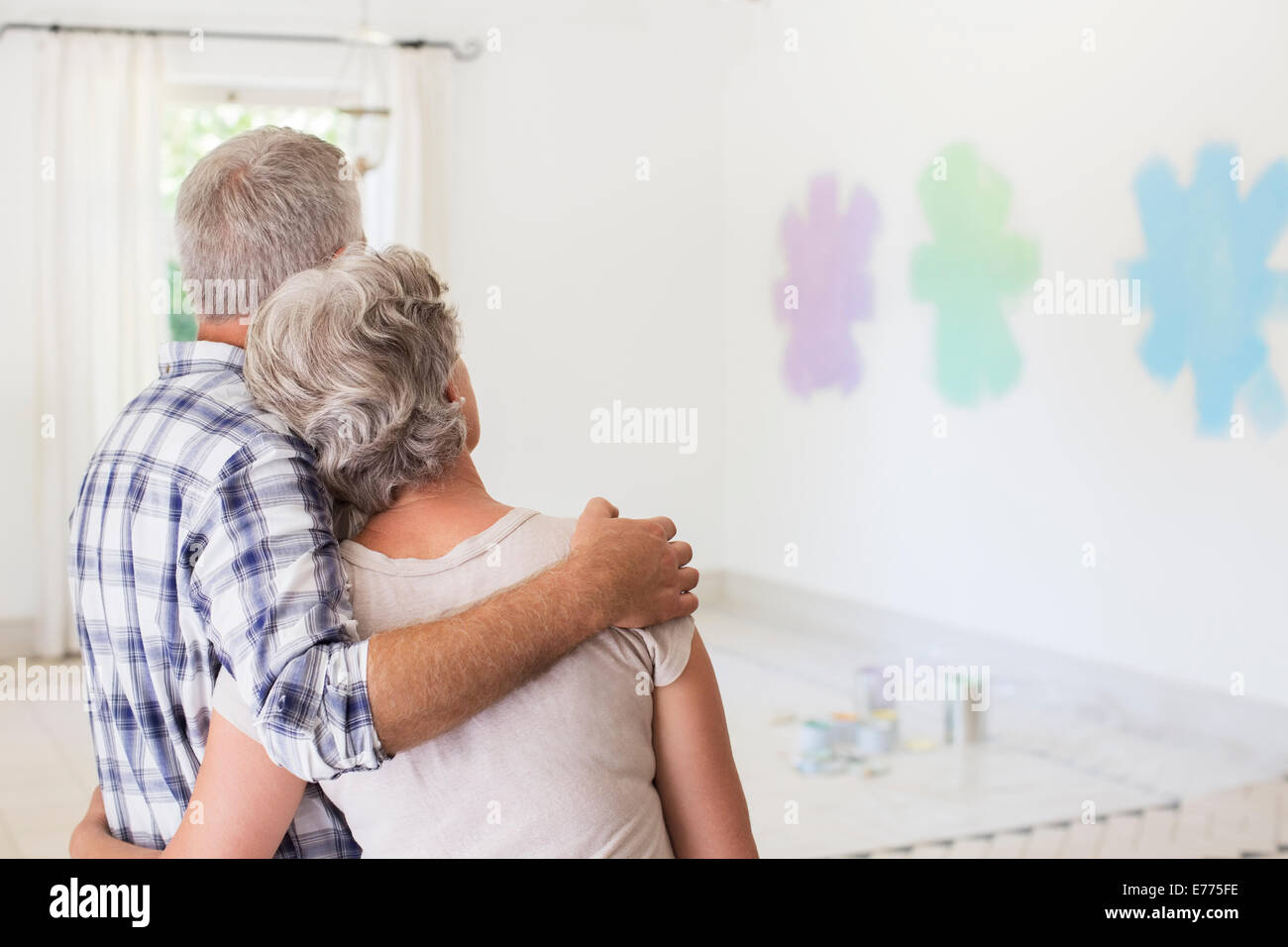 Older couple overlooking paint swatches on wall Stock Photo