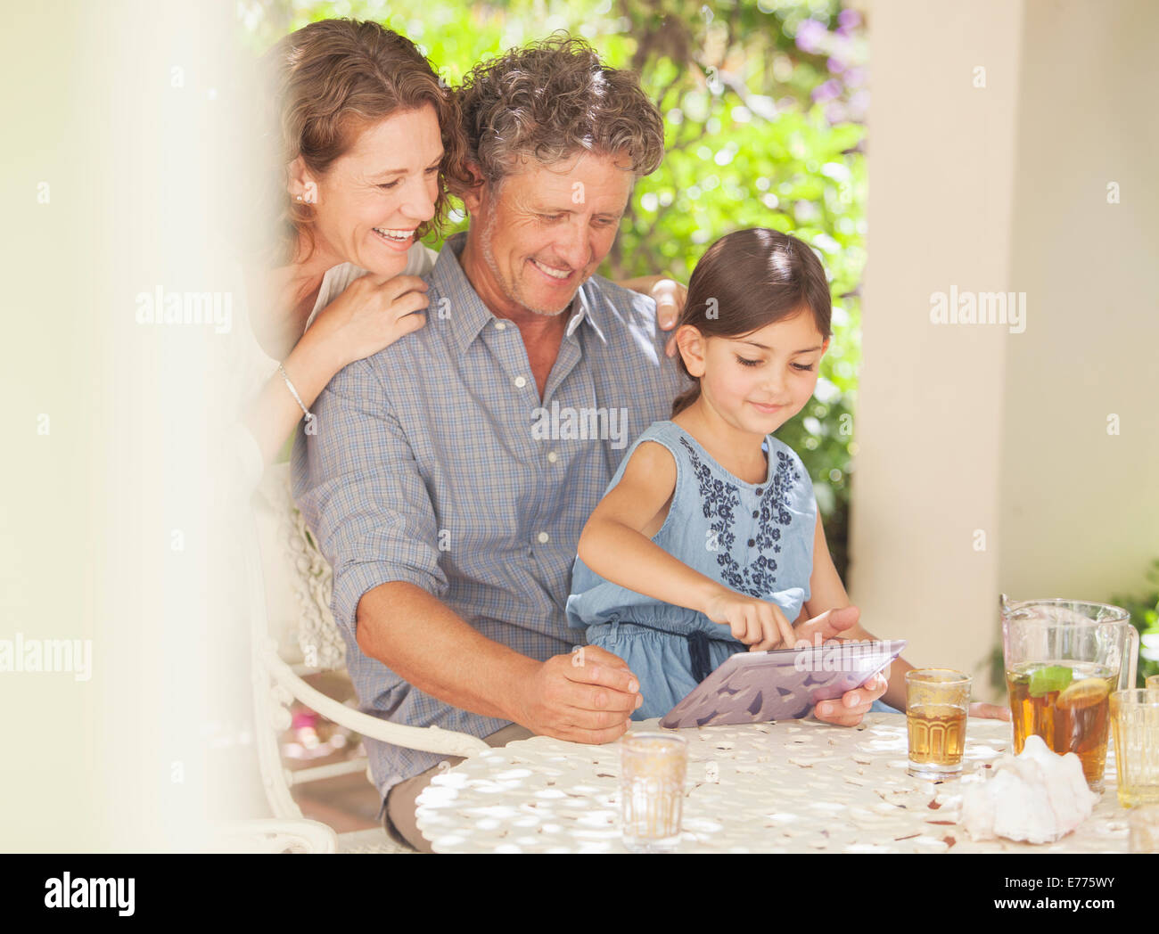 Grandparents playing on digital tablet with granddaughter Stock Photo