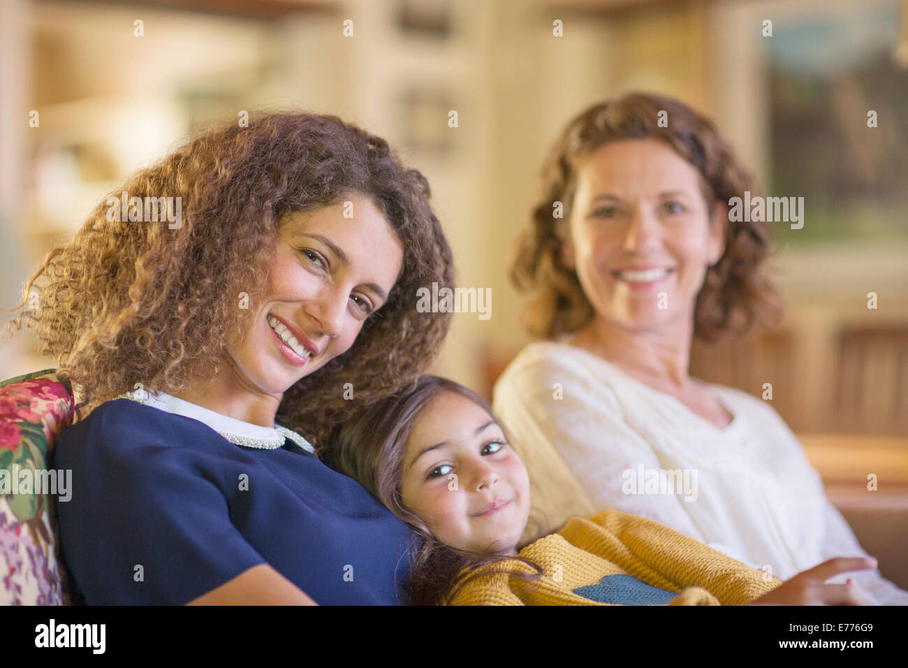 Three generations of women relaxing on couch together Stock Photo