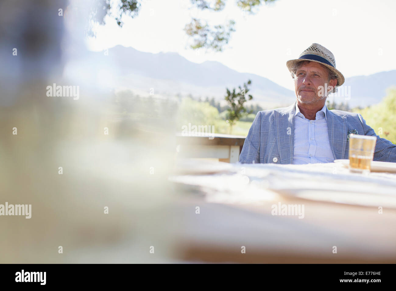 Older man sitting at outdoor dinning table Stock Photo